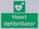 green-background-with-white-text-and-heart-defibrillator-symbol--white-cross-and~